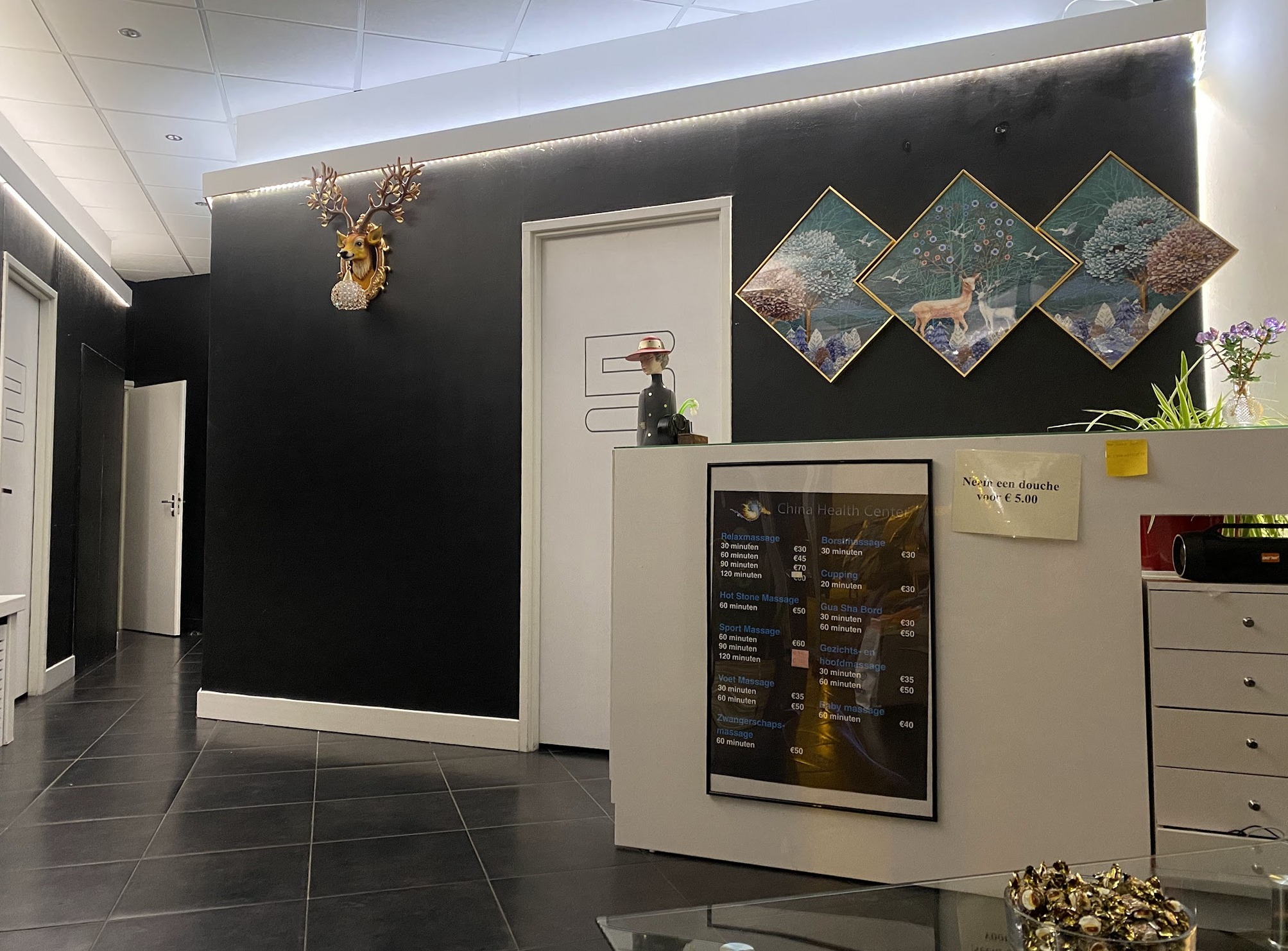 De ontvangstbalie van Asian Health Salon met wanddecoratie