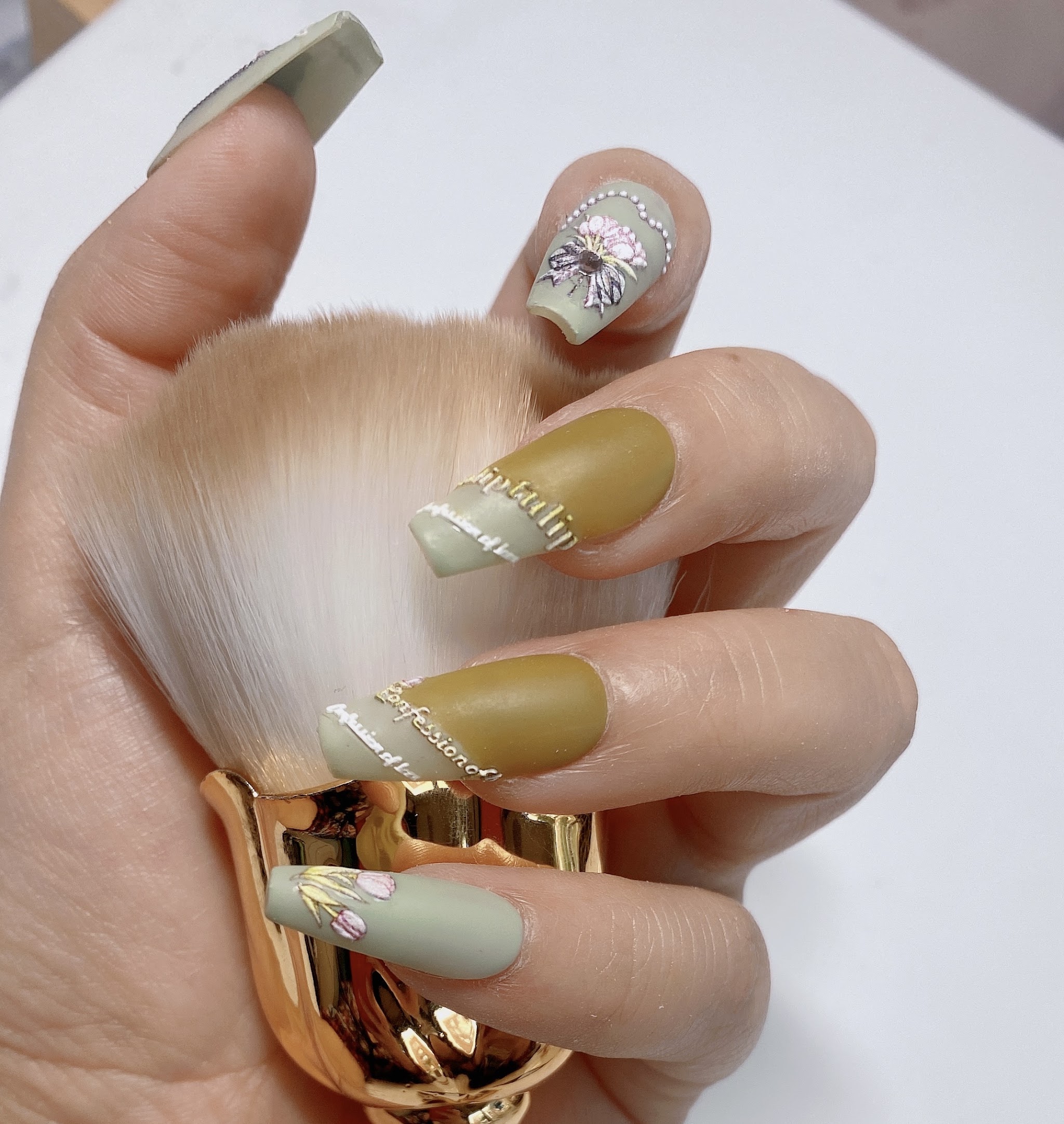 Nagelkunst in zachte groen- en goudtinten met verfijnde versiering