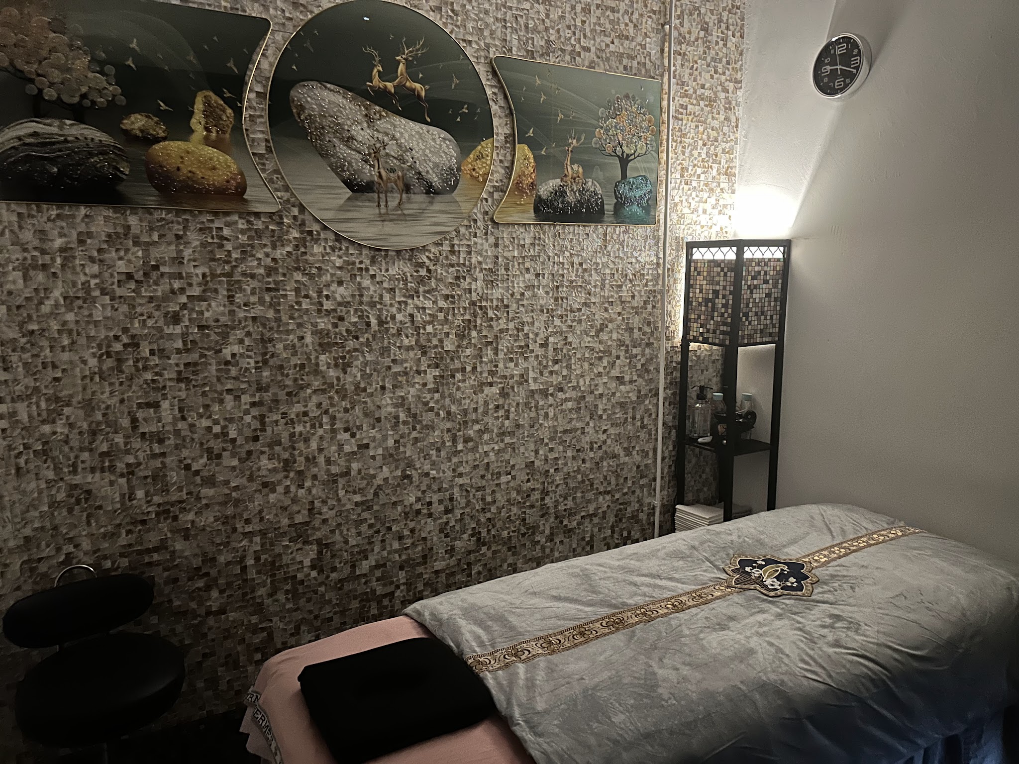 Massageruimte van Asian Health Salon met een opgemaakte behandelbank
