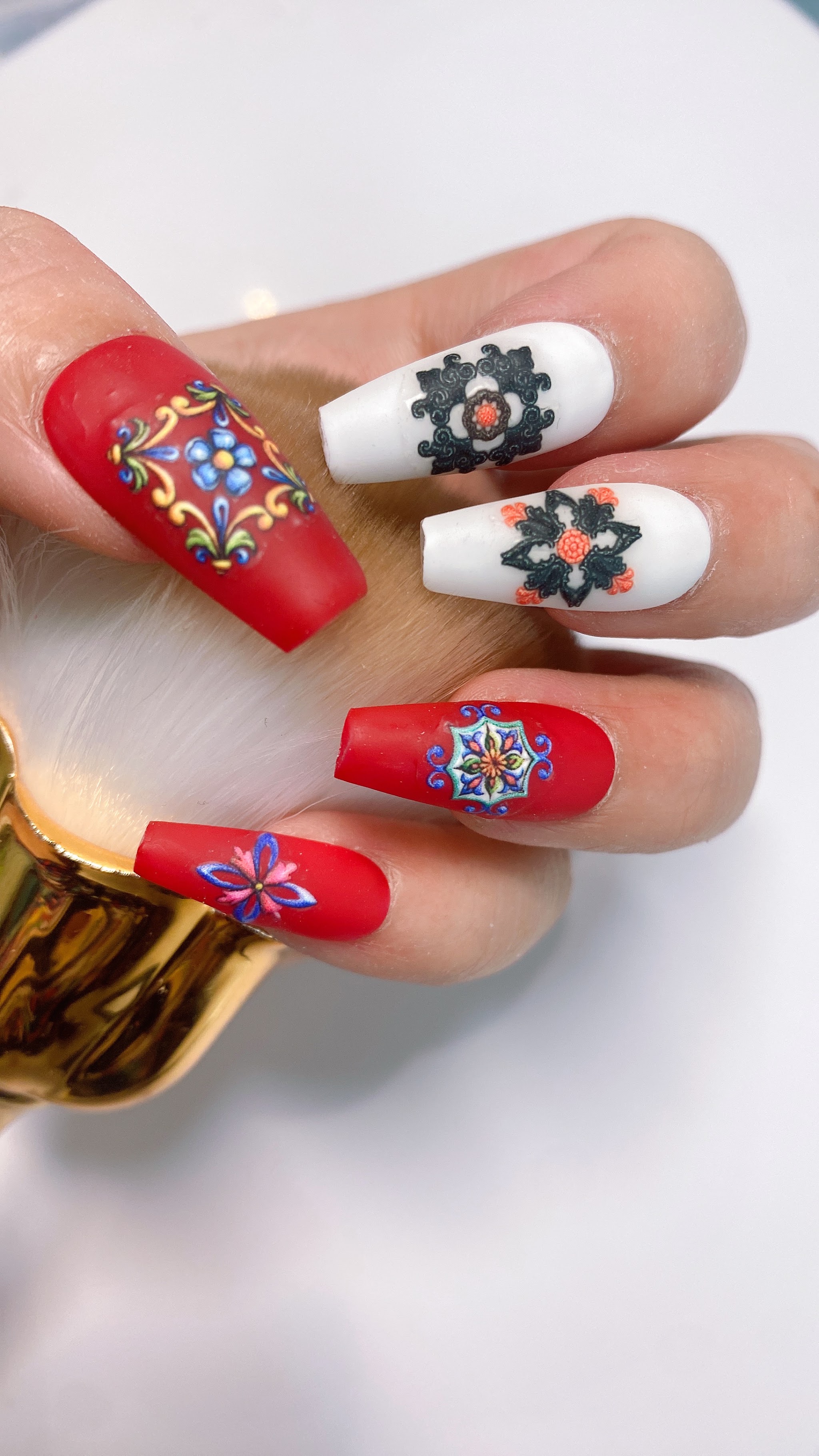 Lange rode en witte nagels met kleurrijke bloemversiering